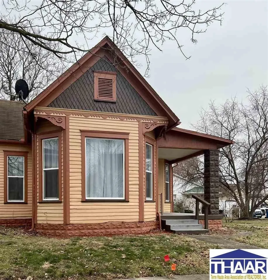 A house with a porch sitting on the side of a hill.