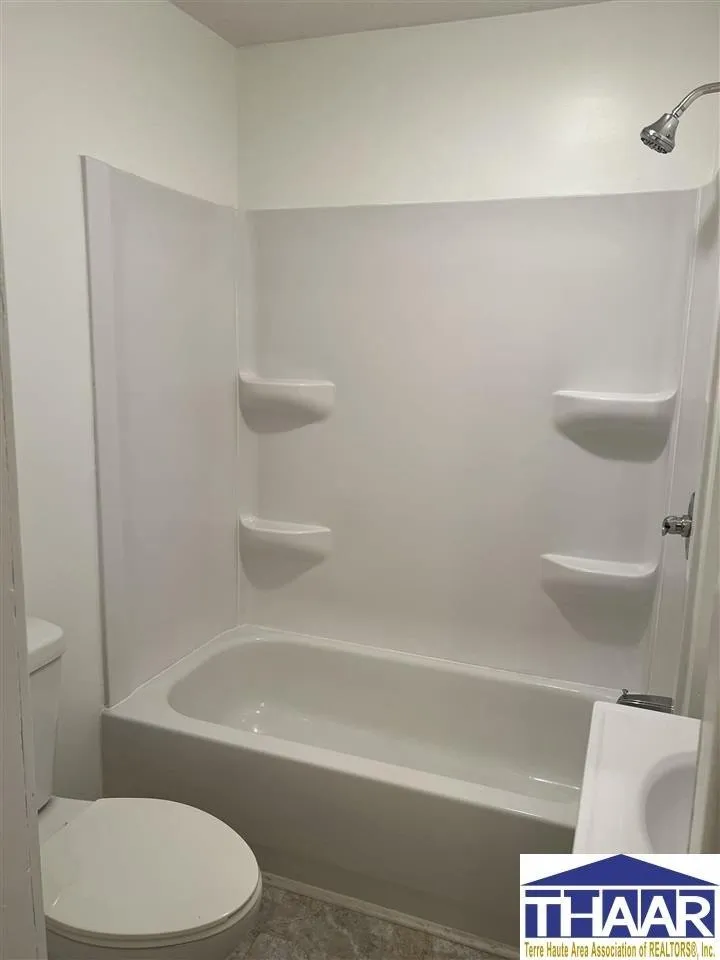 A white bathroom with a tub and shower.