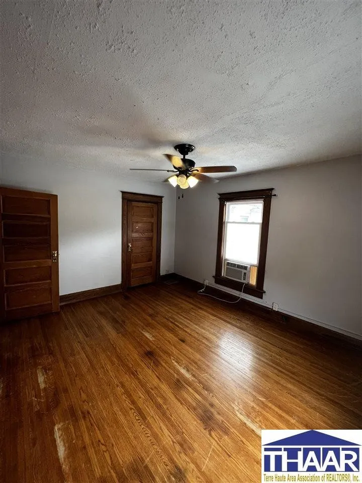 A room with wood floors and ceiling fan.