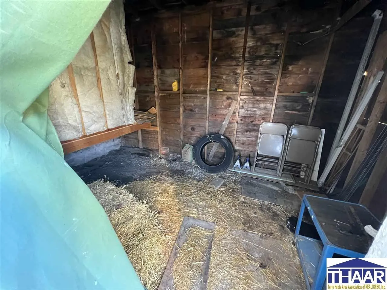 A room with hay and chairs in it