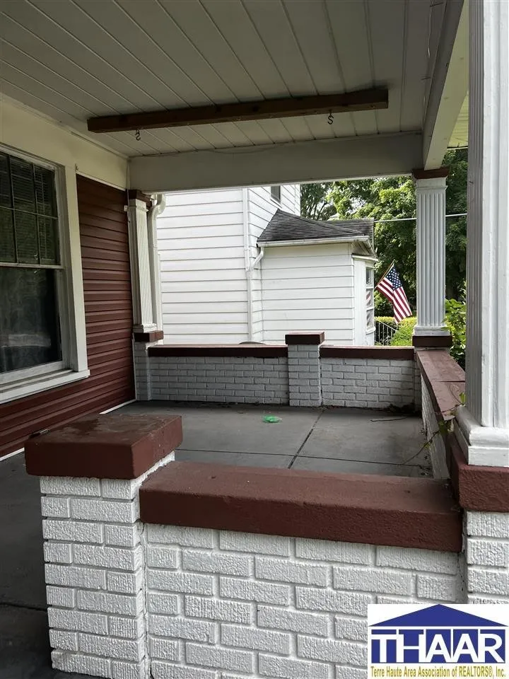 A porch with brick and concrete steps.