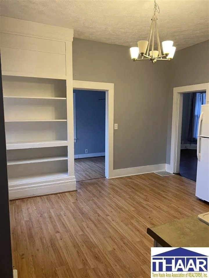 A living room with hard wood floors and white walls.