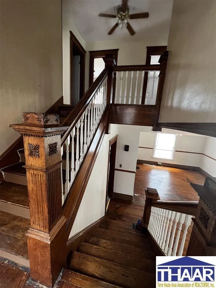 A wooden staircase with wood railing and banister.