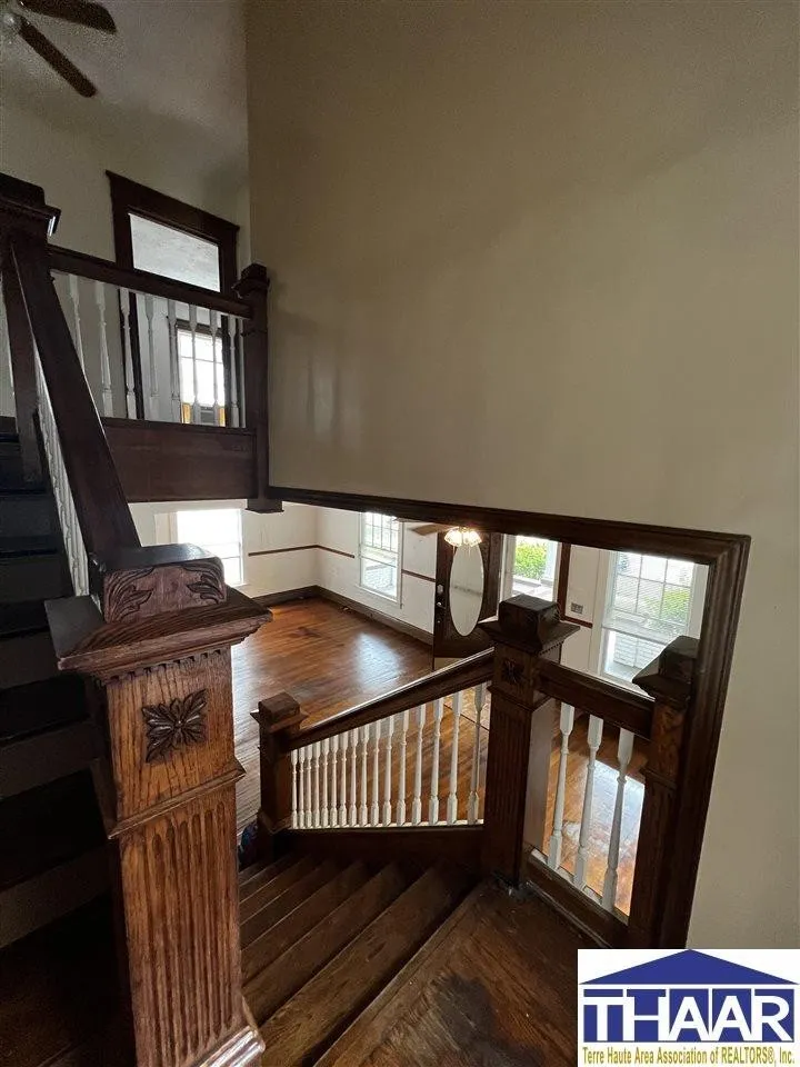 A wooden staircase with wood railing and handrail.