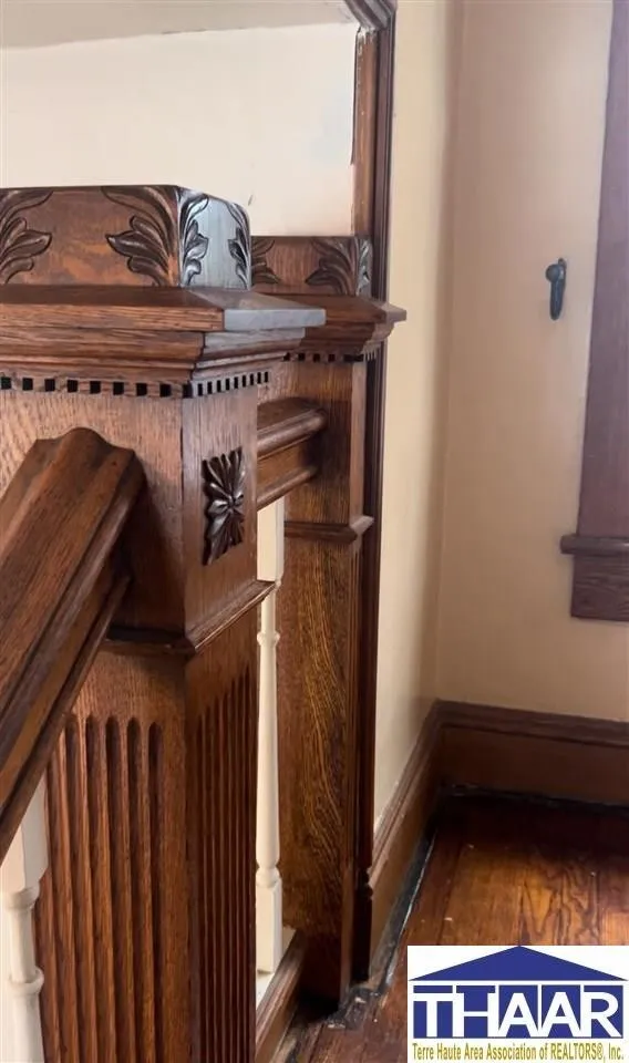 A wooden staircase with an ornate clock on the side.