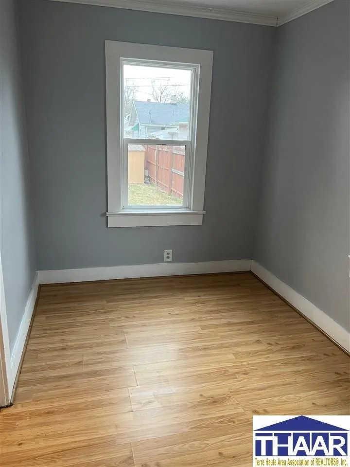 A room with hard wood floors and a window.