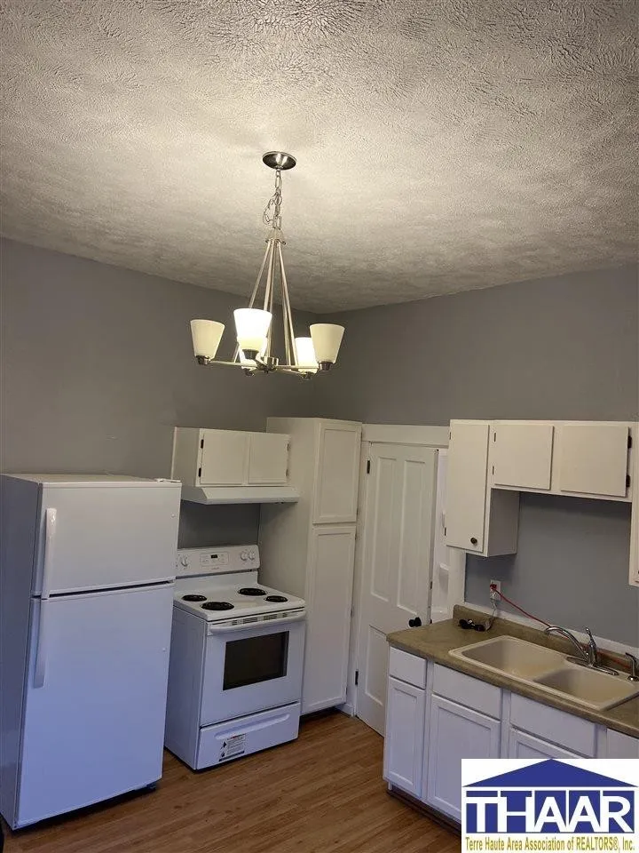 A kitchen with white cabinets and appliances in it